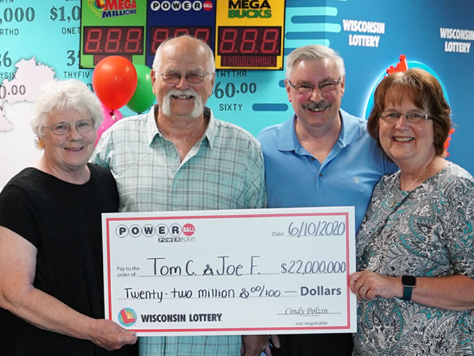 Thomas Cook, left, and Joseph Feeney, right, pictured with their wives after collecting their Powerballprize