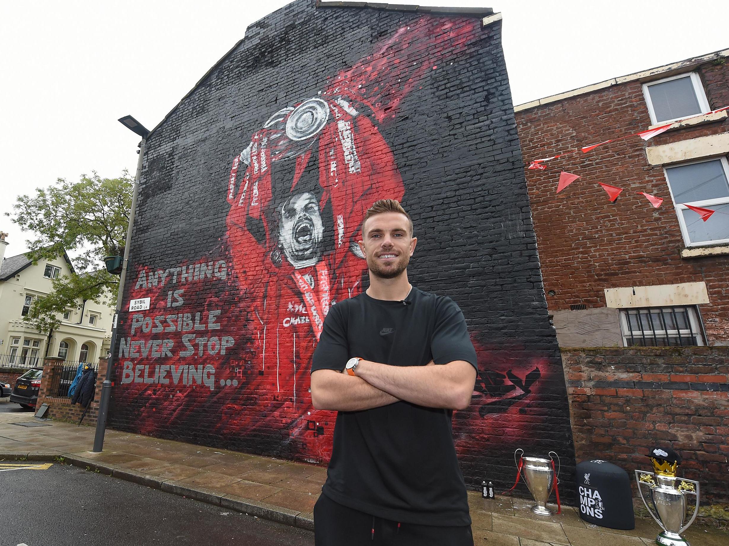 Jordan Henderson poses in front of a mural of himself in Liverpool