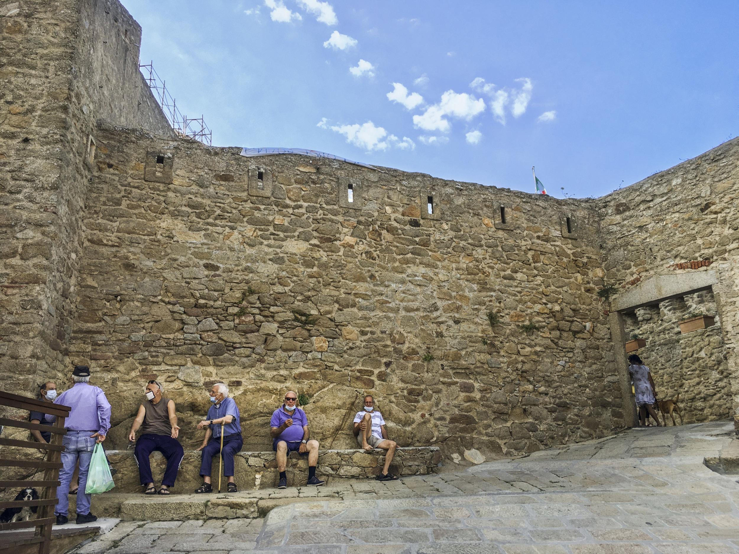 Residents of Giglio island socialize in the steep alleys near the port or on the granite steps that serve as narrow streets in the hilltop Castle neighbourhood, with densely packed homes built against the remnants of a fortress that centuries ago served as protection against pirates