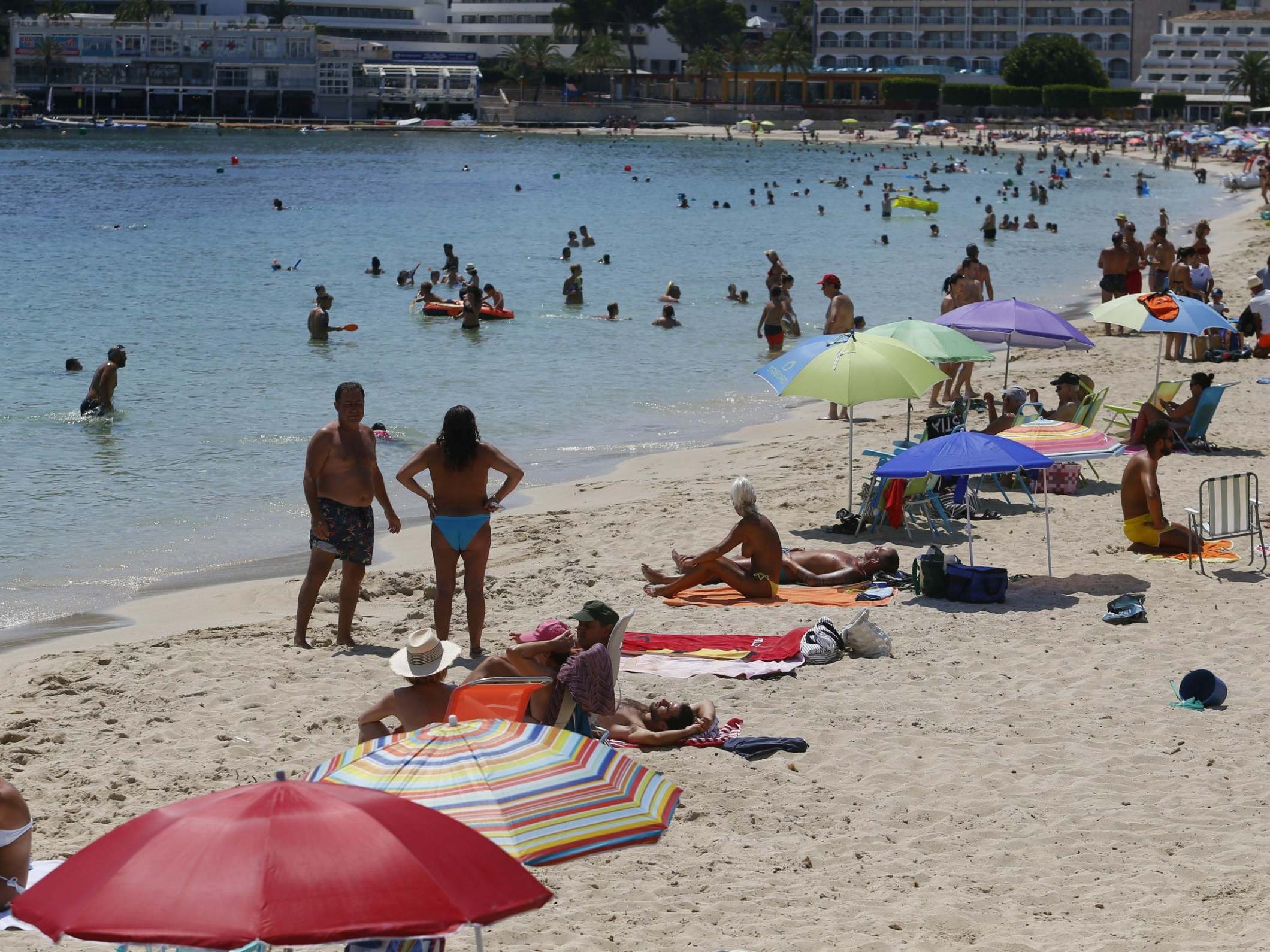 People enjoy Magaluf beach in Mallorca. Britons are surprised at the abrupt announcement to impose a two-week quarantine on people travelling to the UK from Spain