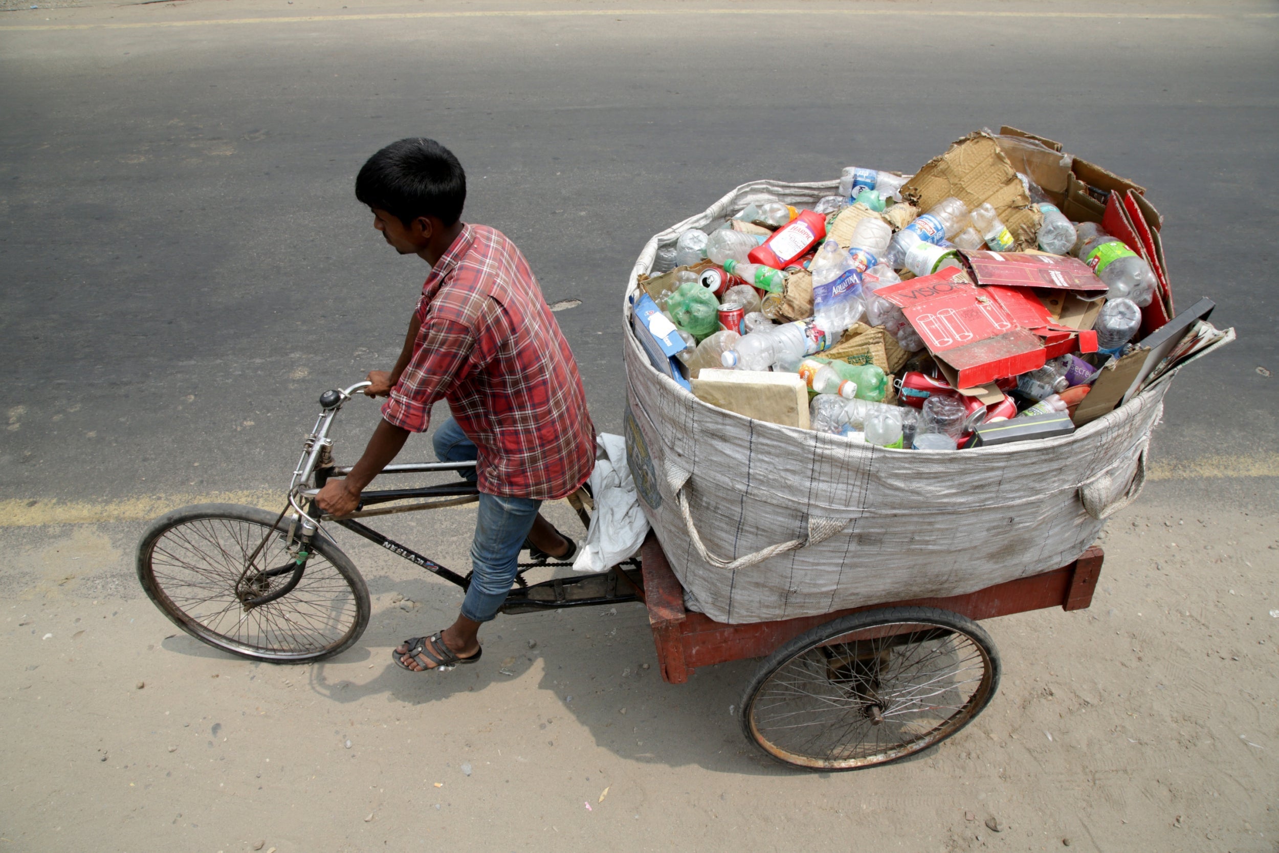 A man transports used plastic bottles and other waste on the outskirts of Jammu, India