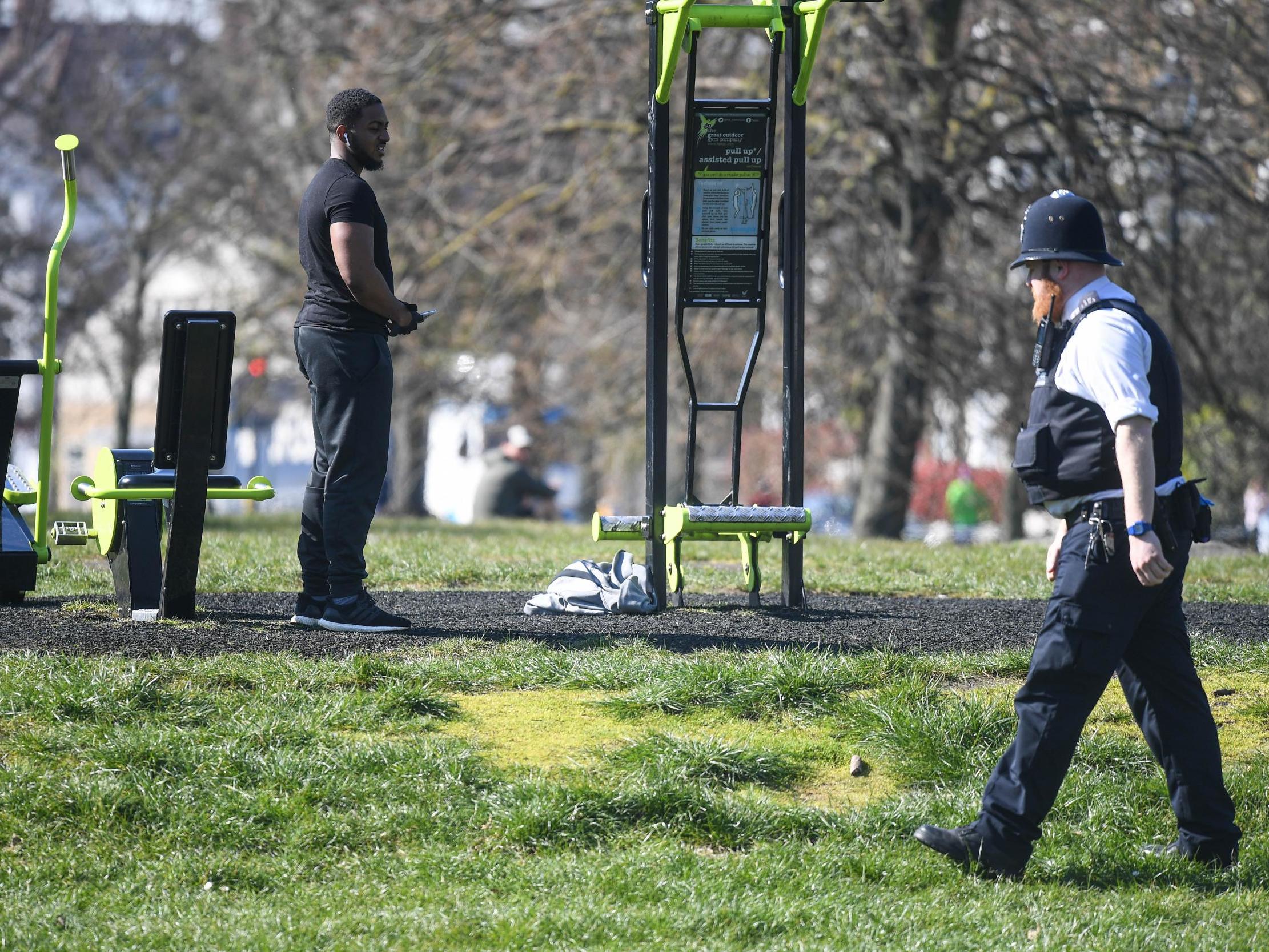 An officer speaks to people exercising on Clapham Common on 25 March