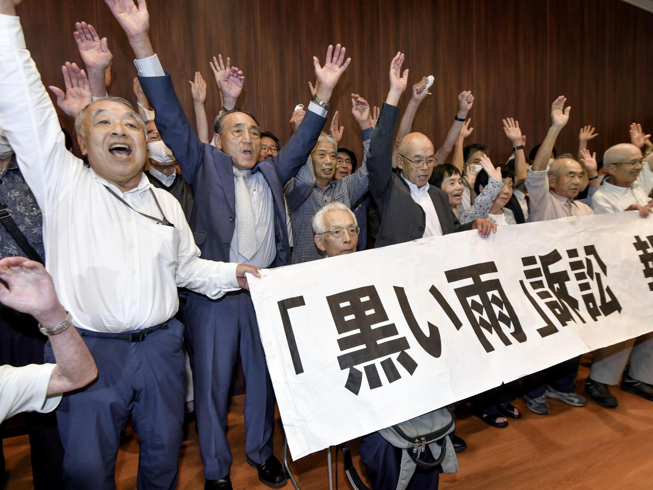 A group of plaintiffs and supporters celebrate during a meeting following the court ruling in Hiroshima, western Japan