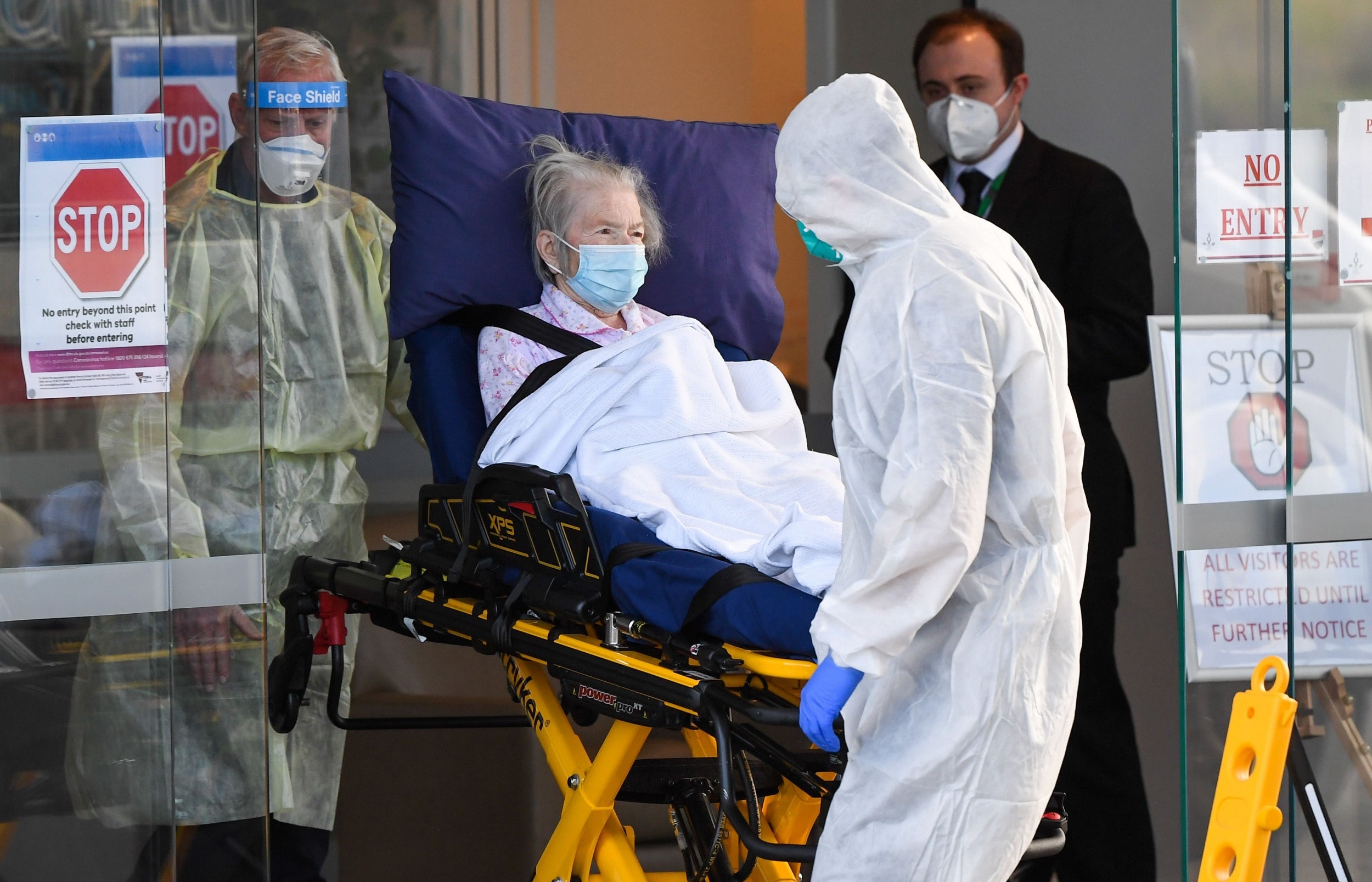 Medical workers evacuate a resident from a care facility in Melbourne