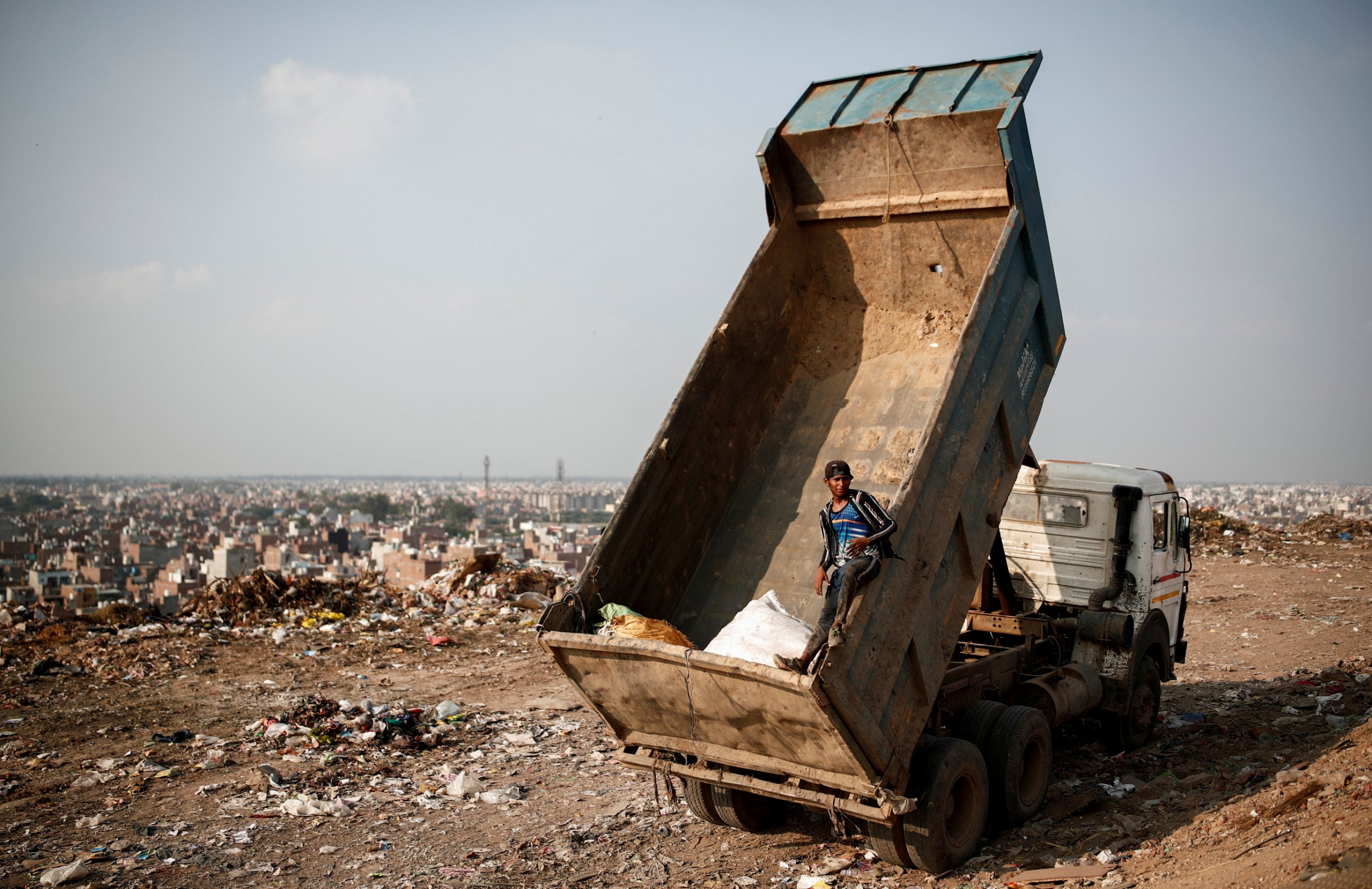 A waste collector stands inside a truck (Reuters)