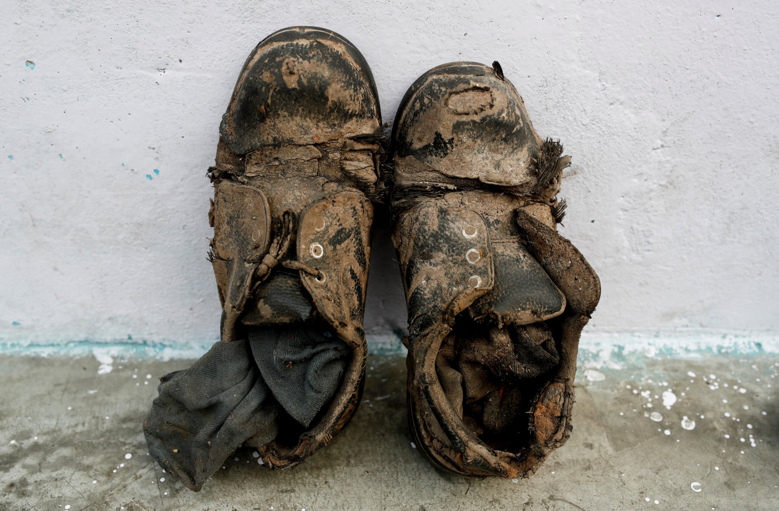 Shoes belonging to Khan are left outside his home (Reuters)