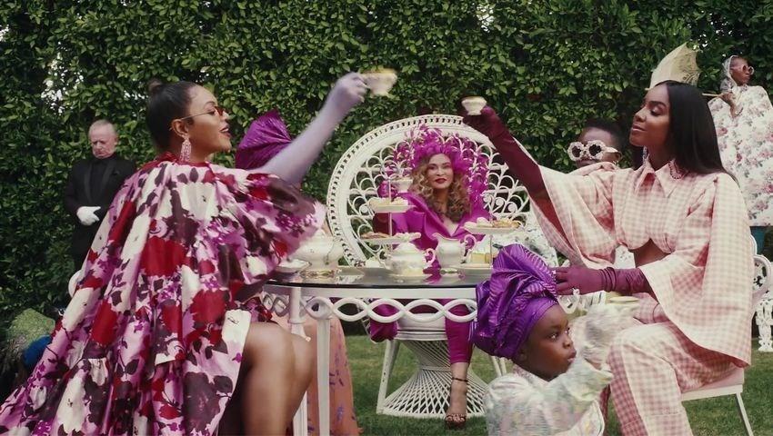 Beyoncé wears a tiered silk gown designed by Erdem that positively blooms with red, pink and purple flowers. The dress first featured in the designer's AW19 runway collection.
