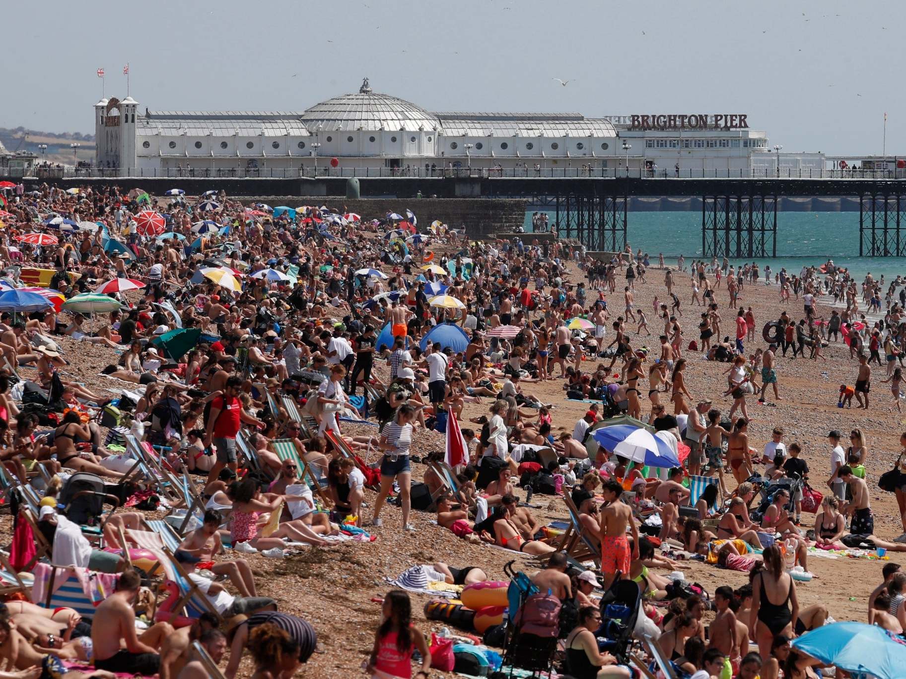 Beachgoers enjoy the sunshine and sea on what is now Britain’s hottest day of the year so far, in Brighton