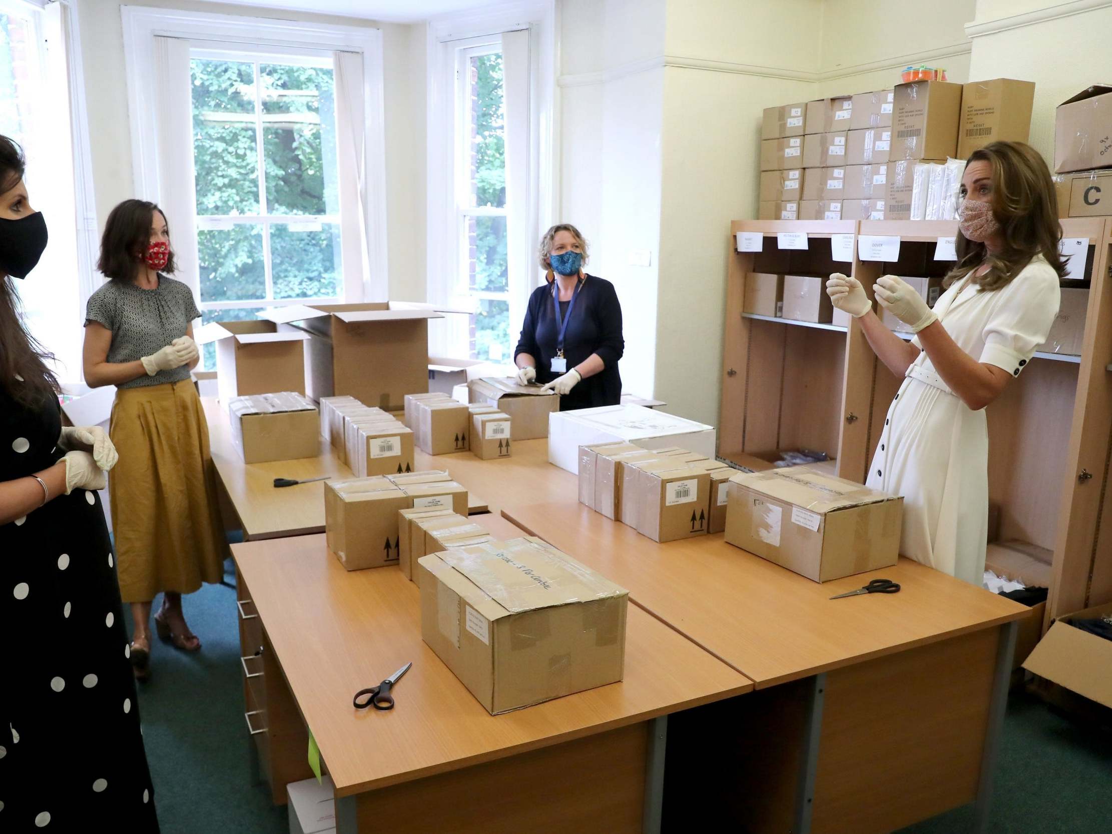 The Duchess of Cambridge wearing a face mask, talks to Founder of Abernecessities Danielle Flecher-Horn, CEO Little Village Sophia Parker and CEO Baby Basics UK Cat Ross during a visit to Baby Basic UK &amp; Baby Basics Sheffield