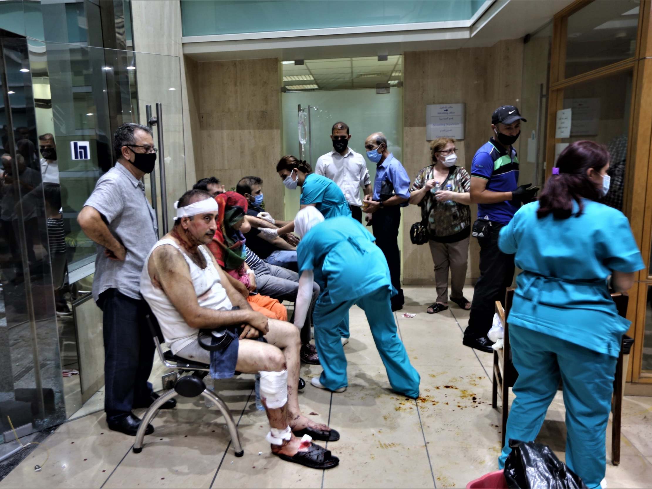 People injured in the Beirut Port explosion receive first aid at Najjar Hospital in Al-Hamra area