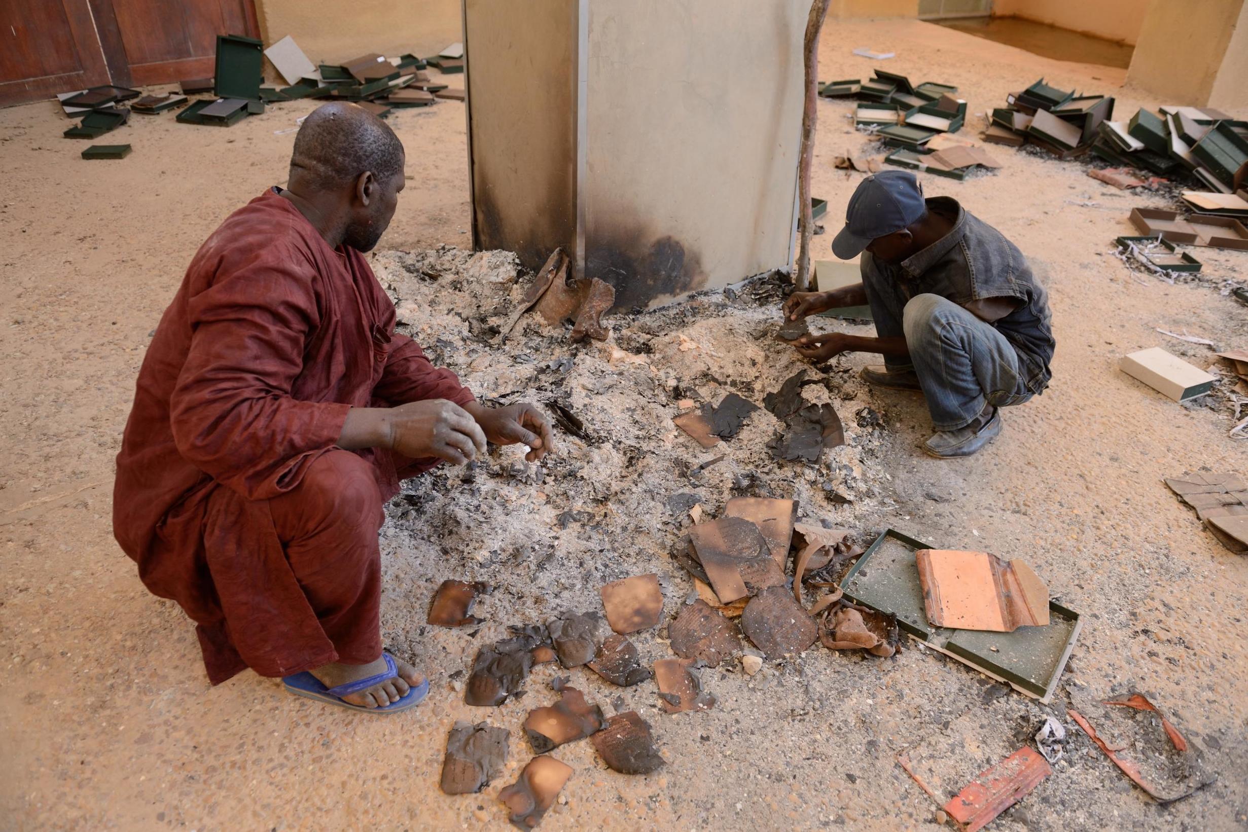 Men sift through burnt ancient manuscripts at the Ahmed Baba Institute in 2013 after Islamists, fleeing French-led forces, torched a building containing between 60,000 and 100,000 documents