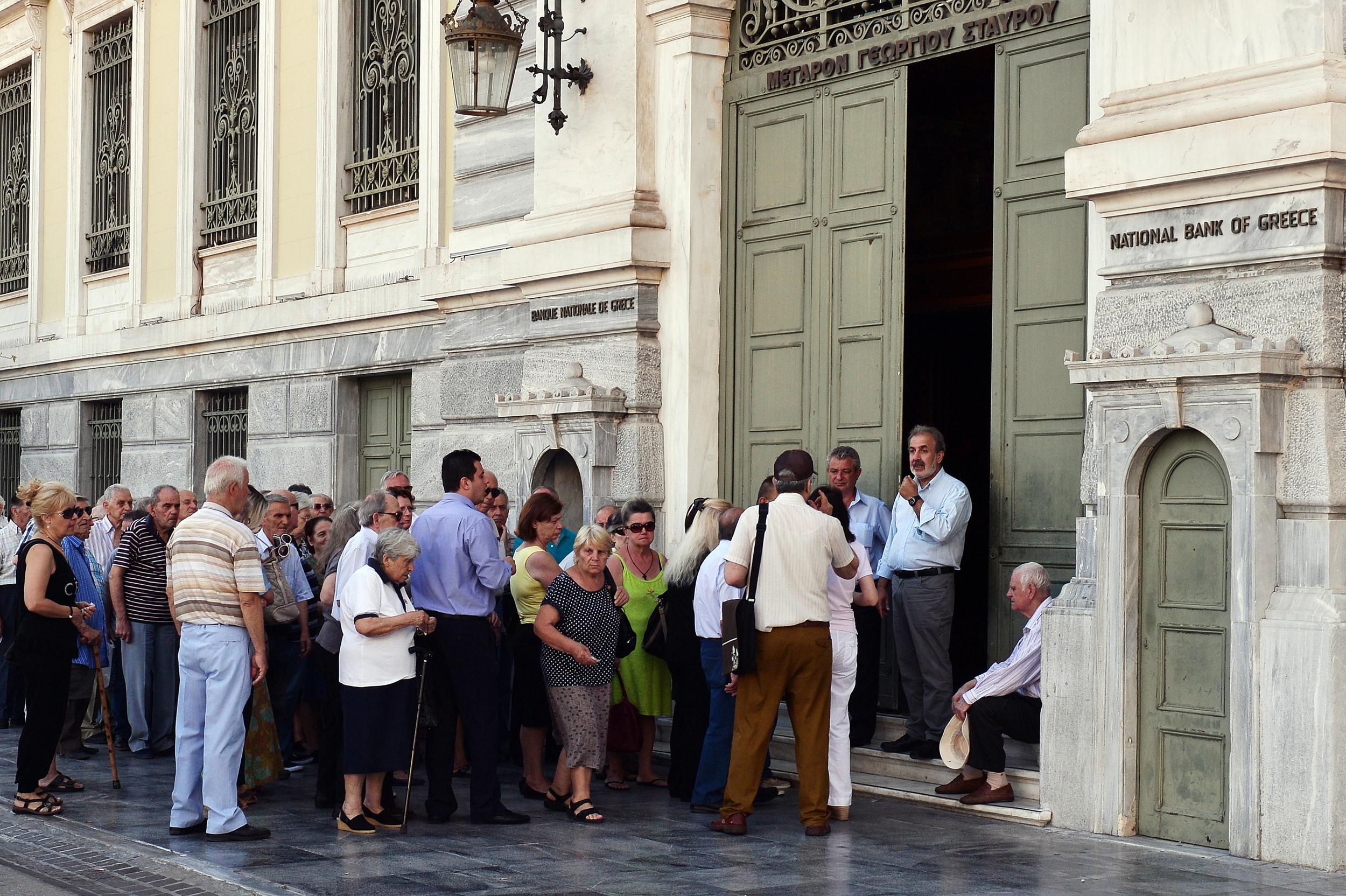 Pensioners queue in front of the National bank of Greece