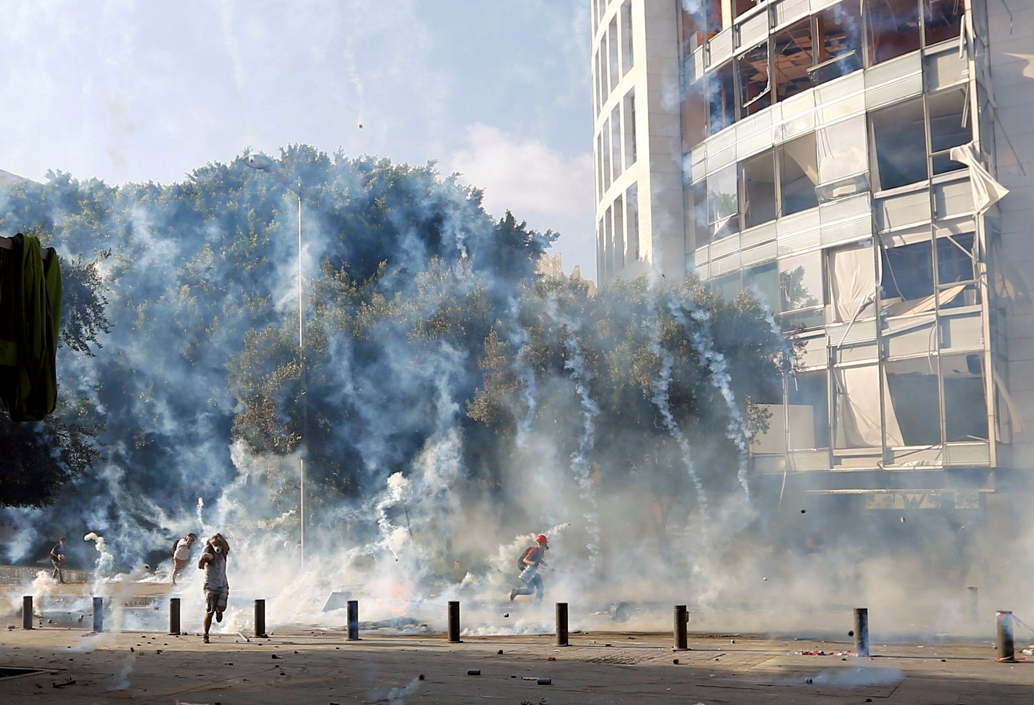 Demonstrators run to take cover from tear gas fired by police during a protest