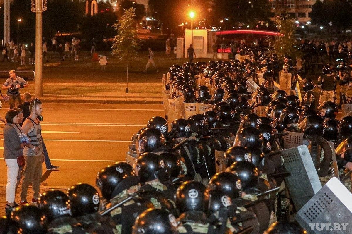 Opposition supporters stay in front of law enforcement officers blocking a street in Minsk (Reuters)