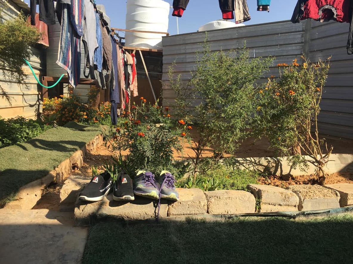 Shoes are left outside in a small garden in a refugee camp in Jordan