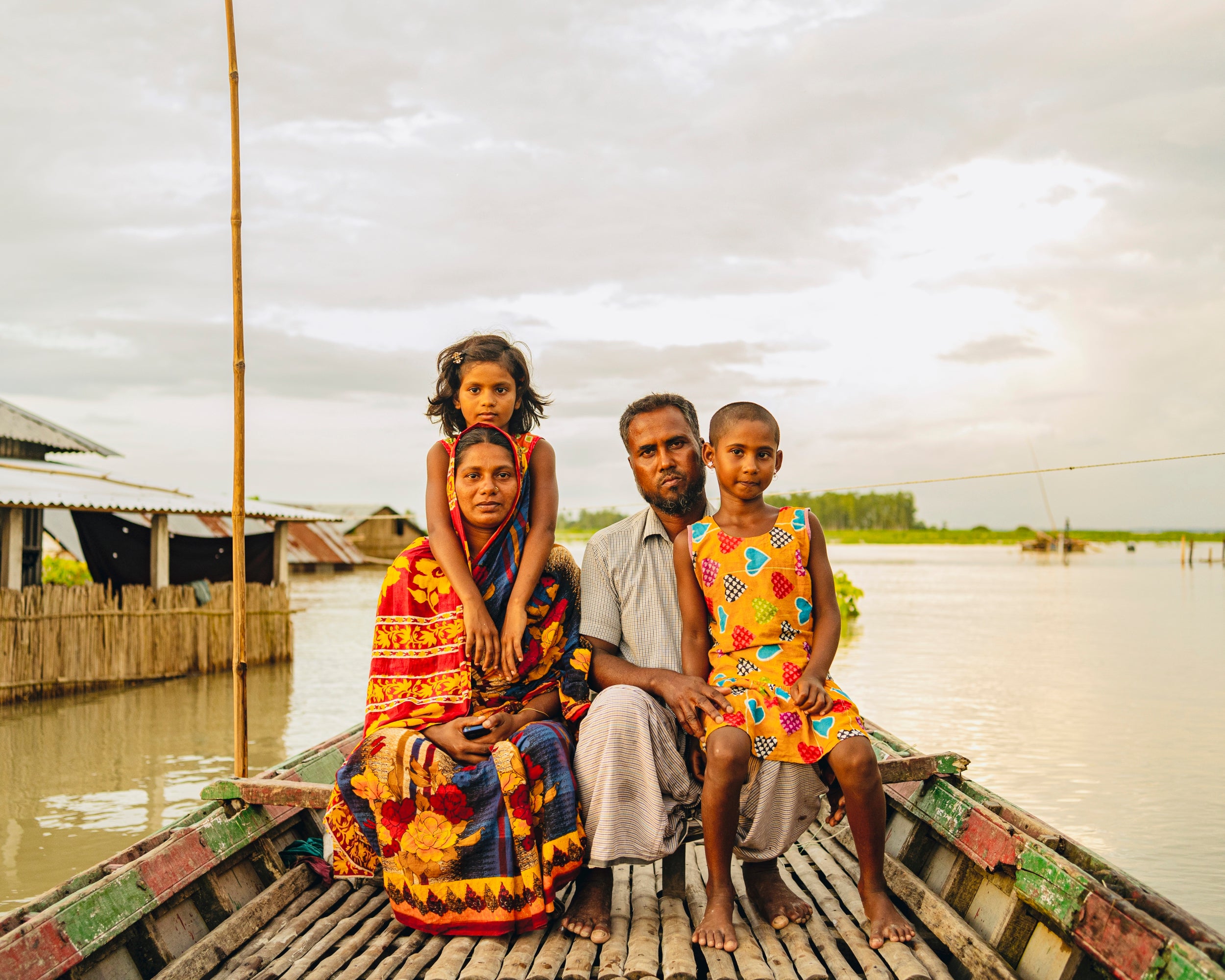 Rowshan Ara, Shahidul Islam and their daughters at their submerged yard (WFP/Sayed Asif Mahmud)