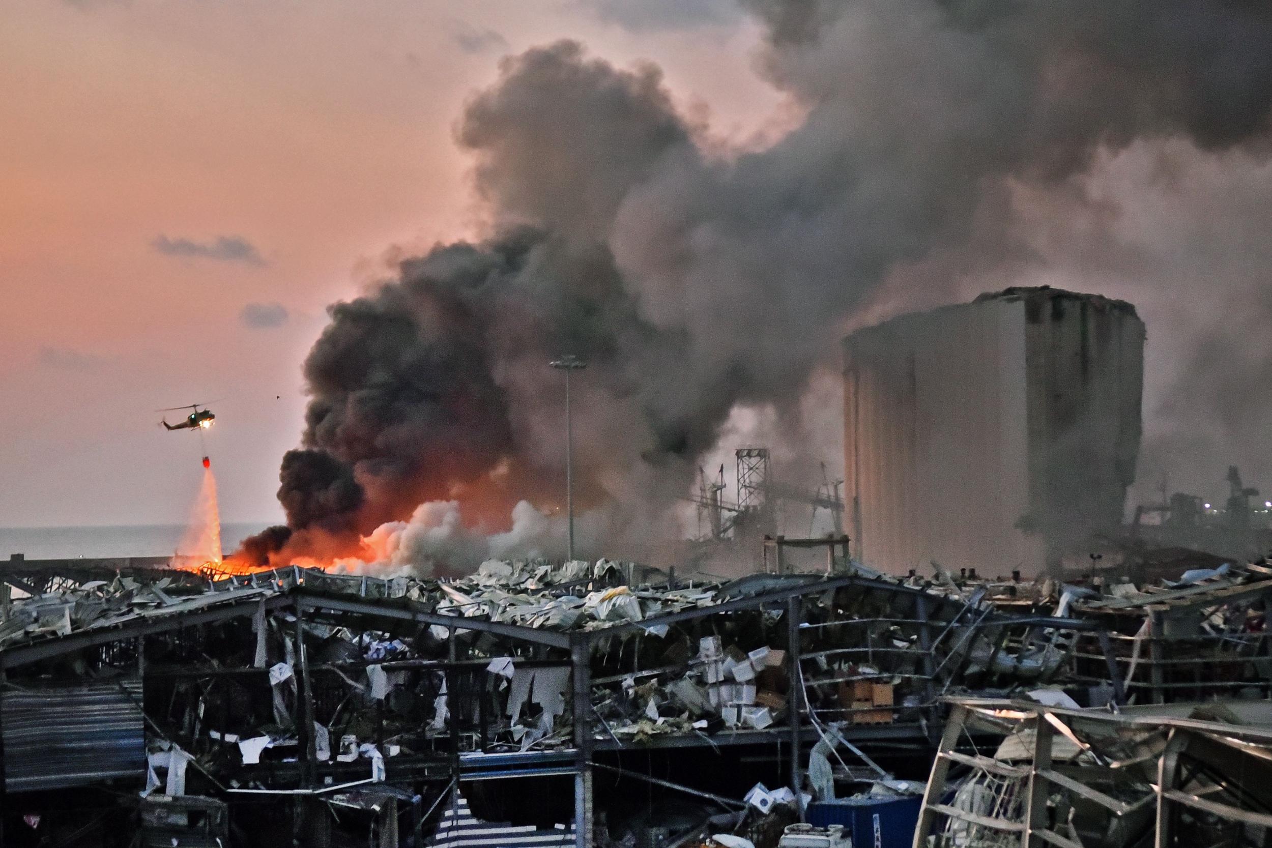 A helicopter puts out a fire at the scene of the explosion at the port of Lebanon’s capital