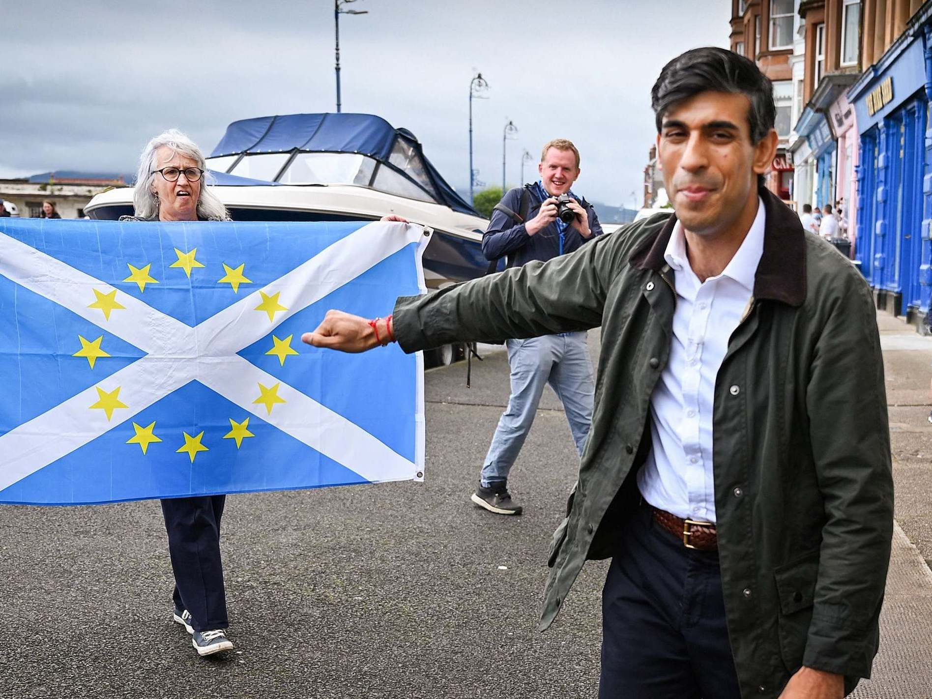 A pro-independence demonstrator holds a flag as she welcomes chancellor Rishi Sunak to Scotland