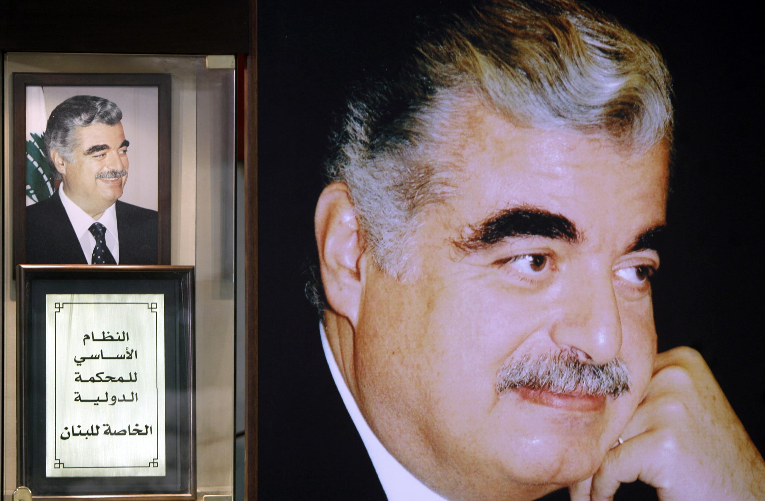 A replica of the text of the STL sits next to pictures of slain Lebanese ex-premier Rafiq Hariri at his shrine site in downtown Beirut on 12 January 2011 (AFP/Getty)