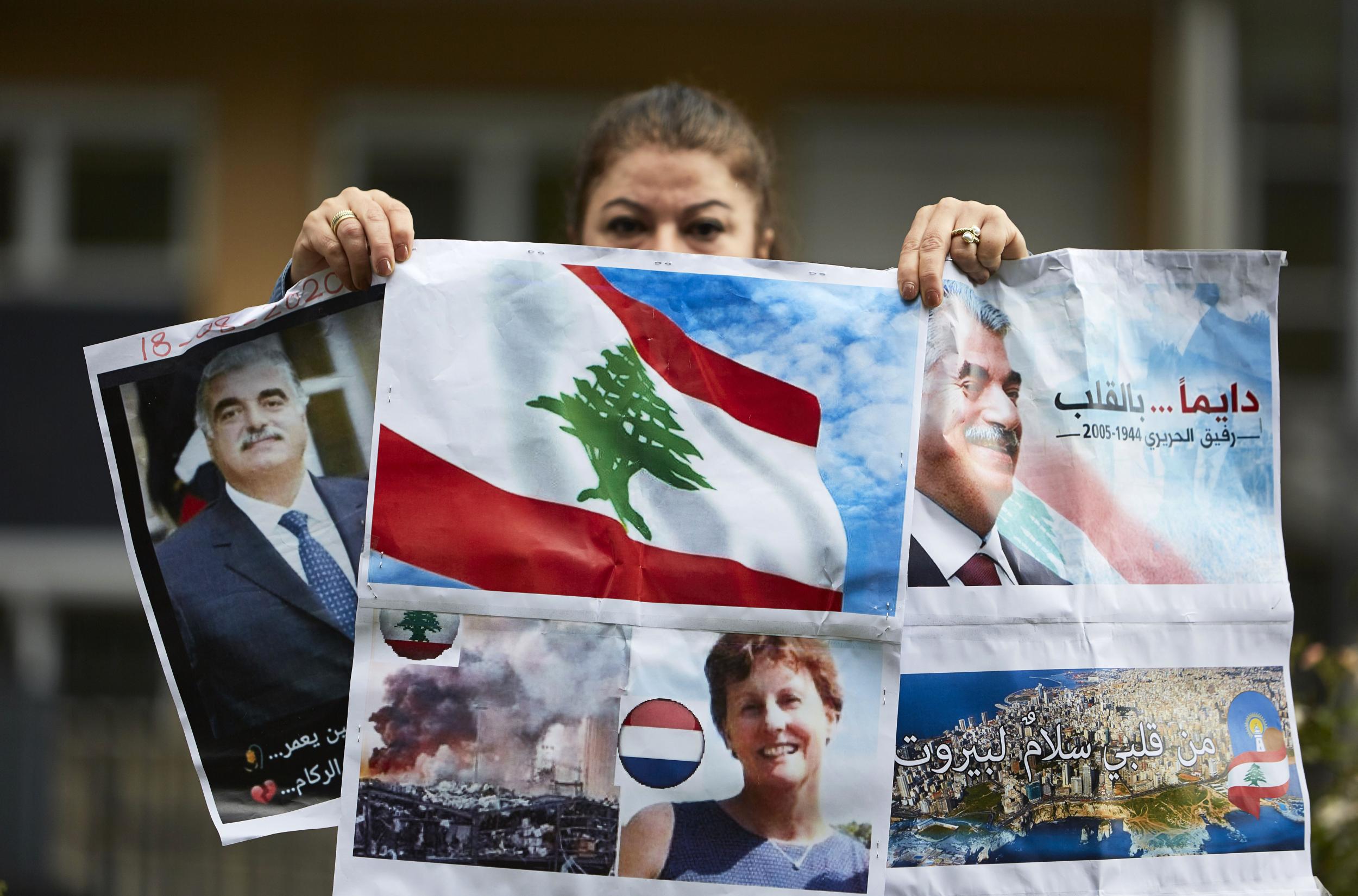 A supporter of former Prime Minister Rafiq Hariri holds posters outside the Lebanon Tribunal on August 18, 2020 in The Hague, Netherland