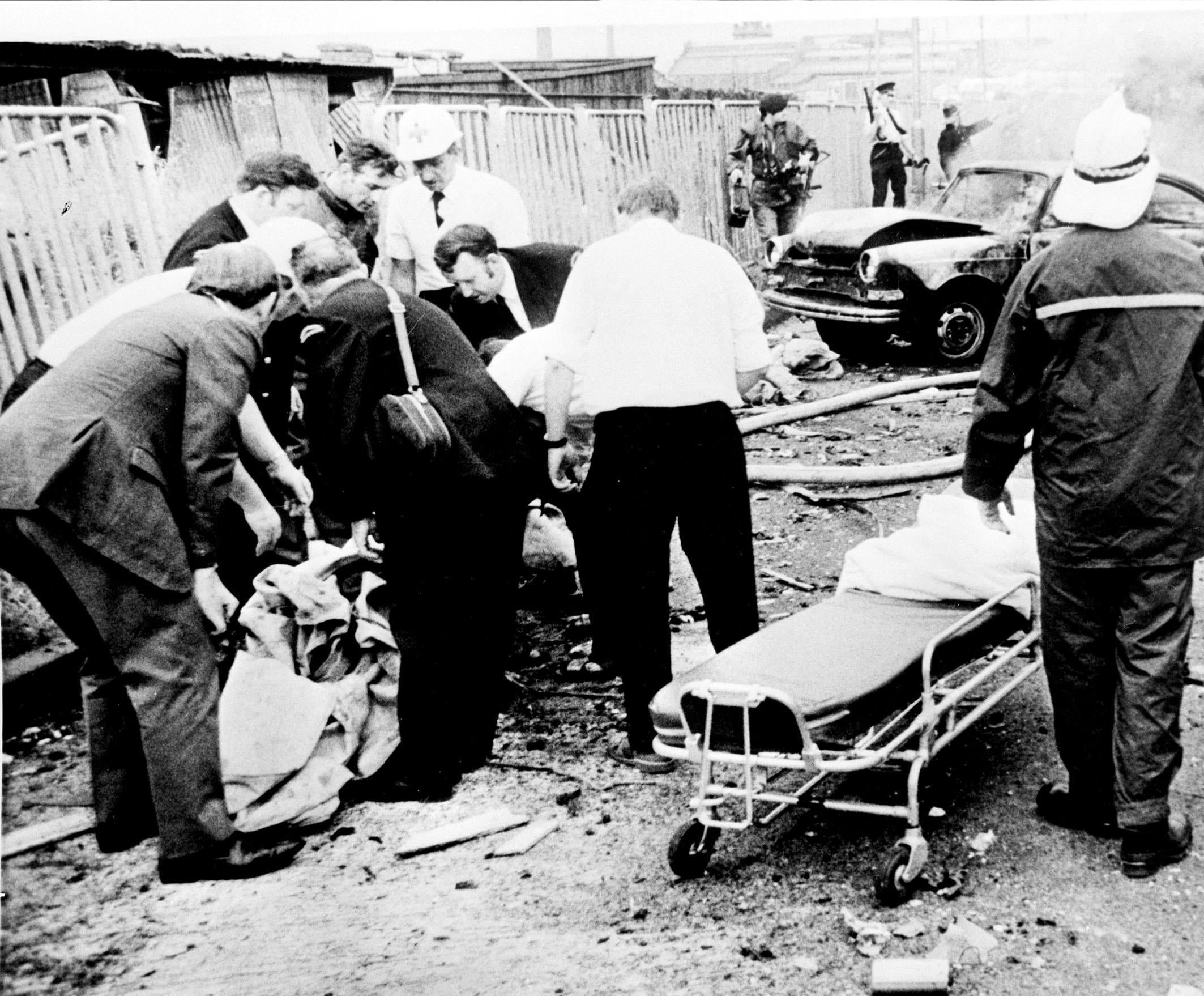 Rescue workers lift the remains of a body into a polythene bag after an explosion in Belfast in 1972