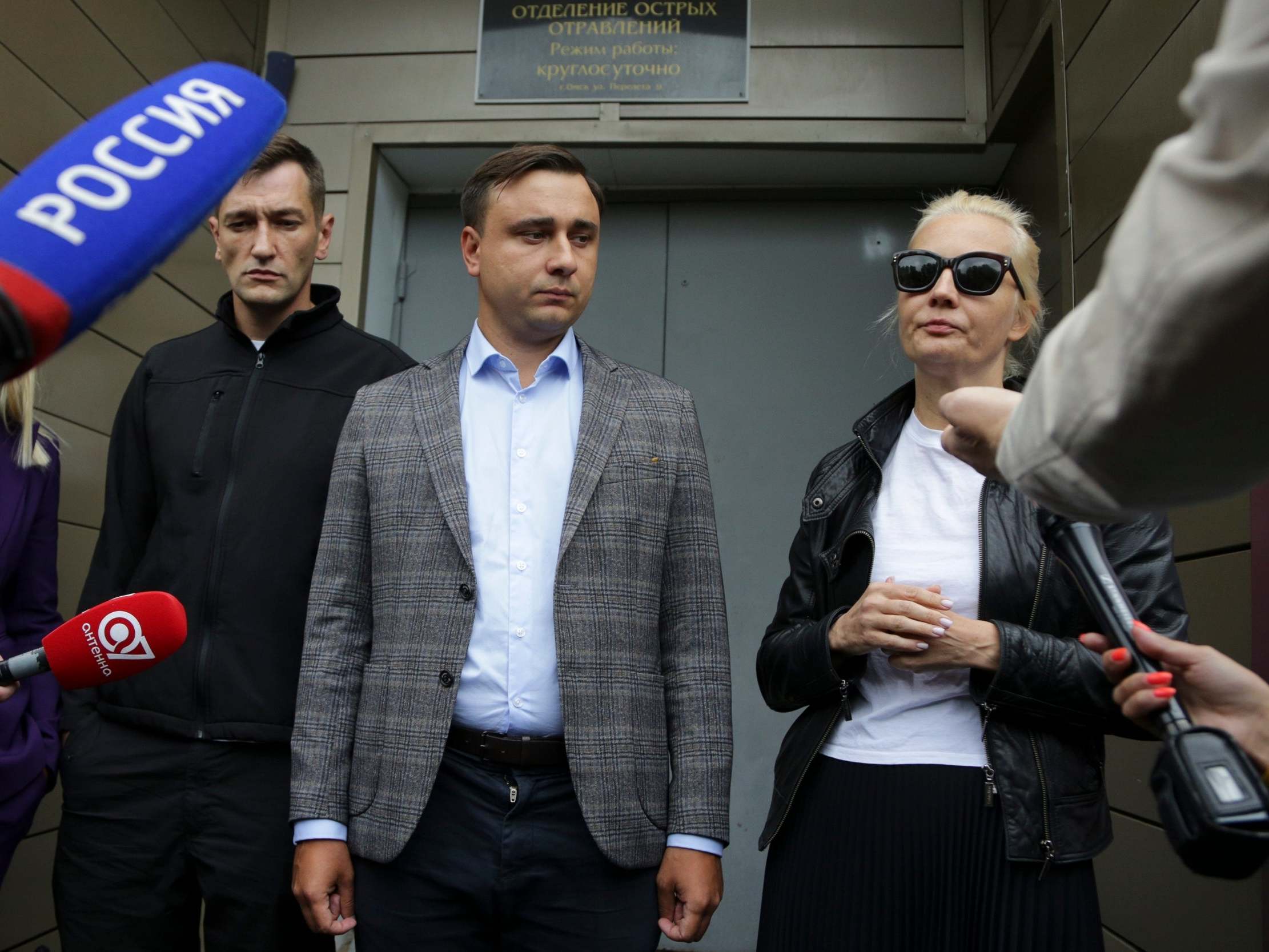 Alexei Navalny's brother Oleg Navalny (left), colleague Ivan Zhdanov (centre), and wife Yulia speak to the media at the hospital in Omsk