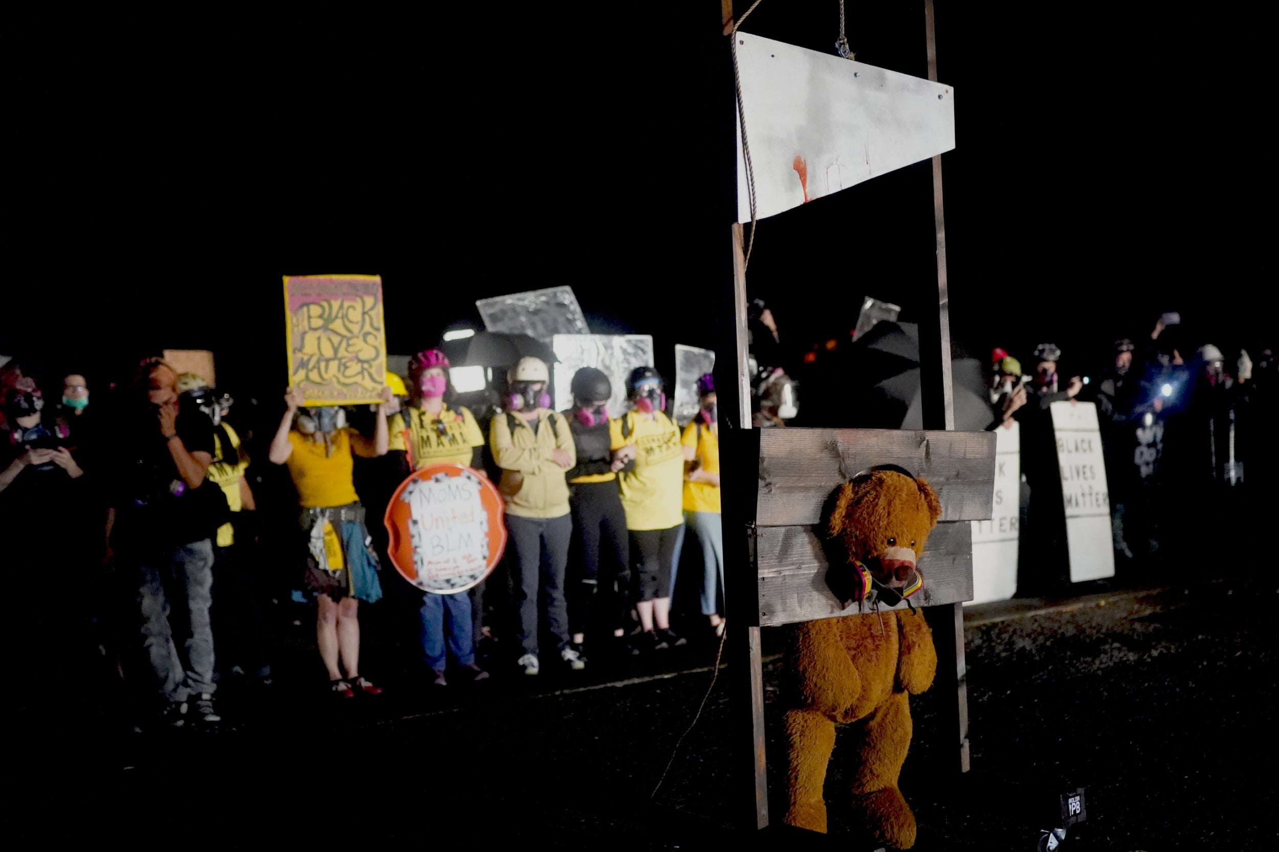 Portland protesters burn Maga hats and guillotine giant teddy bear on eve of Trump convention