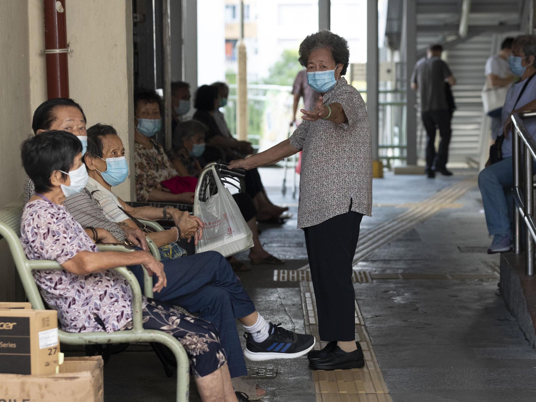 People wearing face masks as a precautionary measure against the Covid-19 coronavirus sit together in Hong Kong