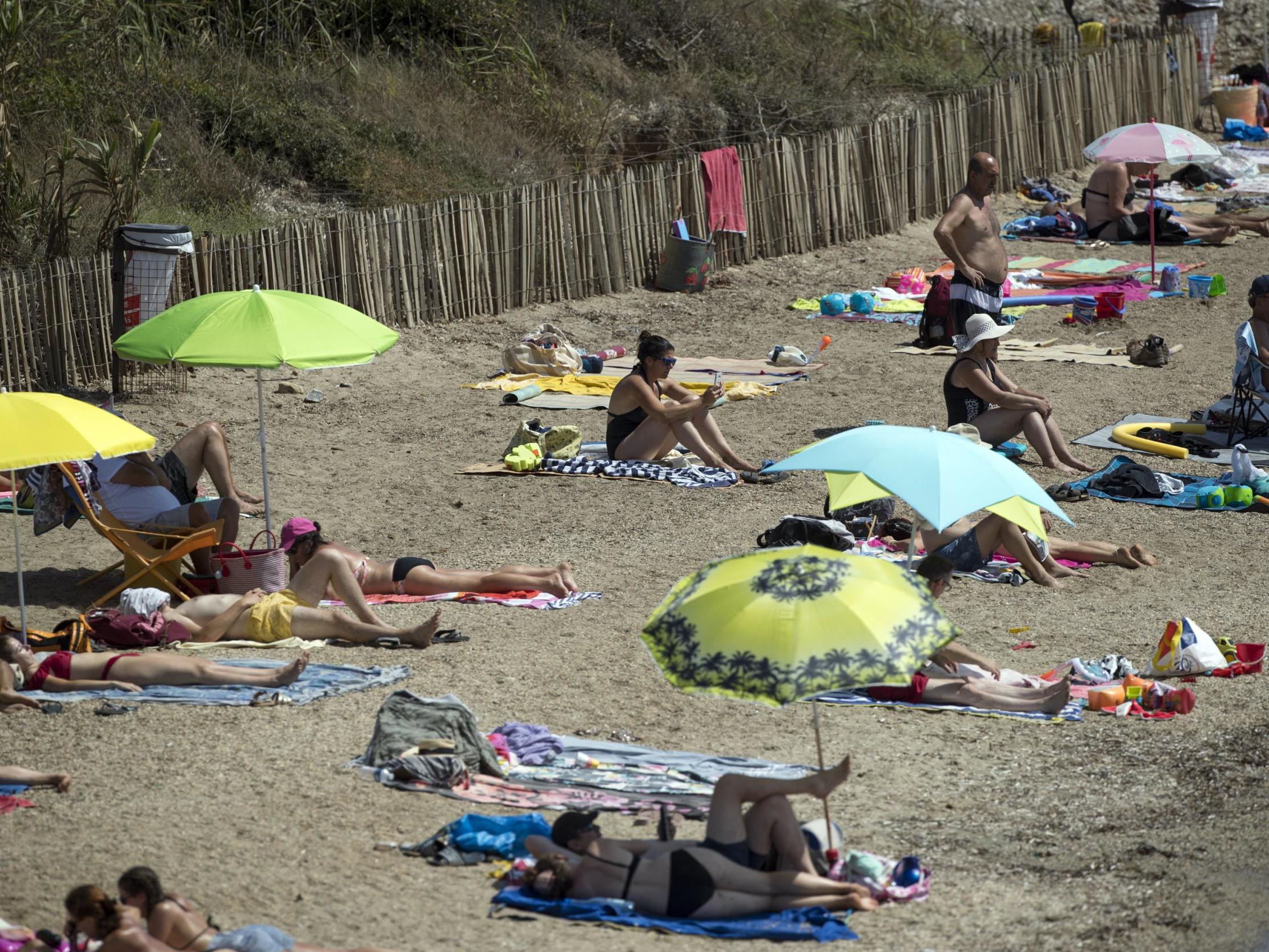 People bask in the sun at a beach in southern France on 11 August, 2020.