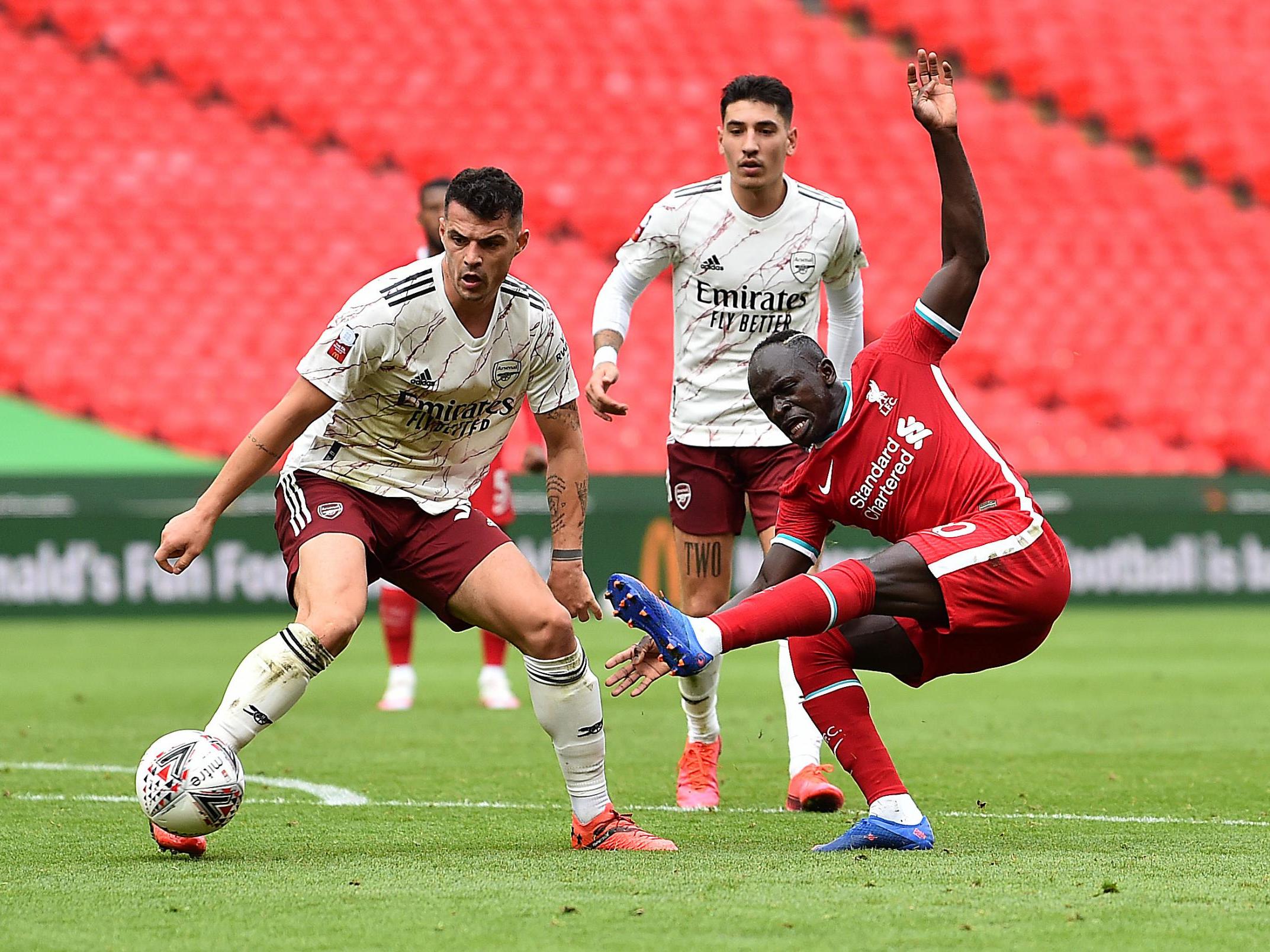 Granit Xhaka of Arsenal (left) battles with Liverpool's Sadio Mane at Wembley