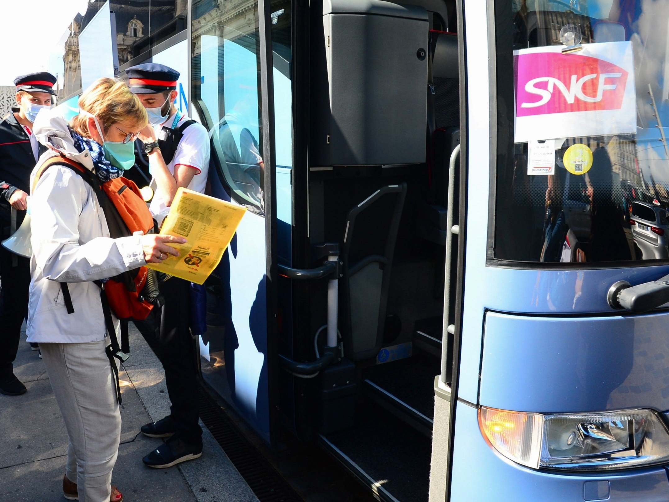 SNCF passengers board a bus in front of Bordeaux St-Jean train station in Bordeaux, southern France to reach stations further south after thousands of travellers were stranded aboard their train in the region following electrical incidents