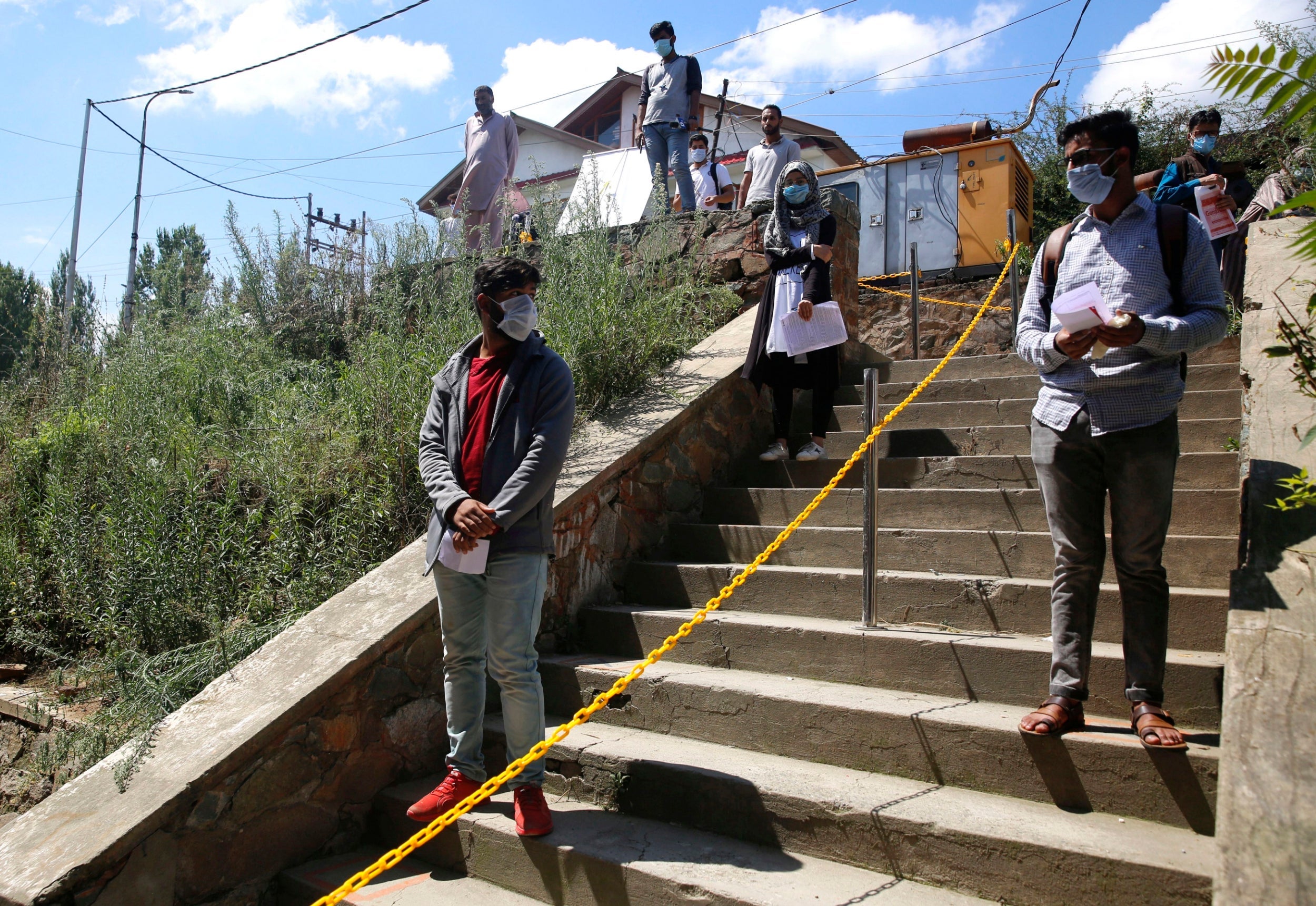 Students maintain social distance while waiting to take key college exams on the outskirts of Srinagar, in Kashmir, on 1 September