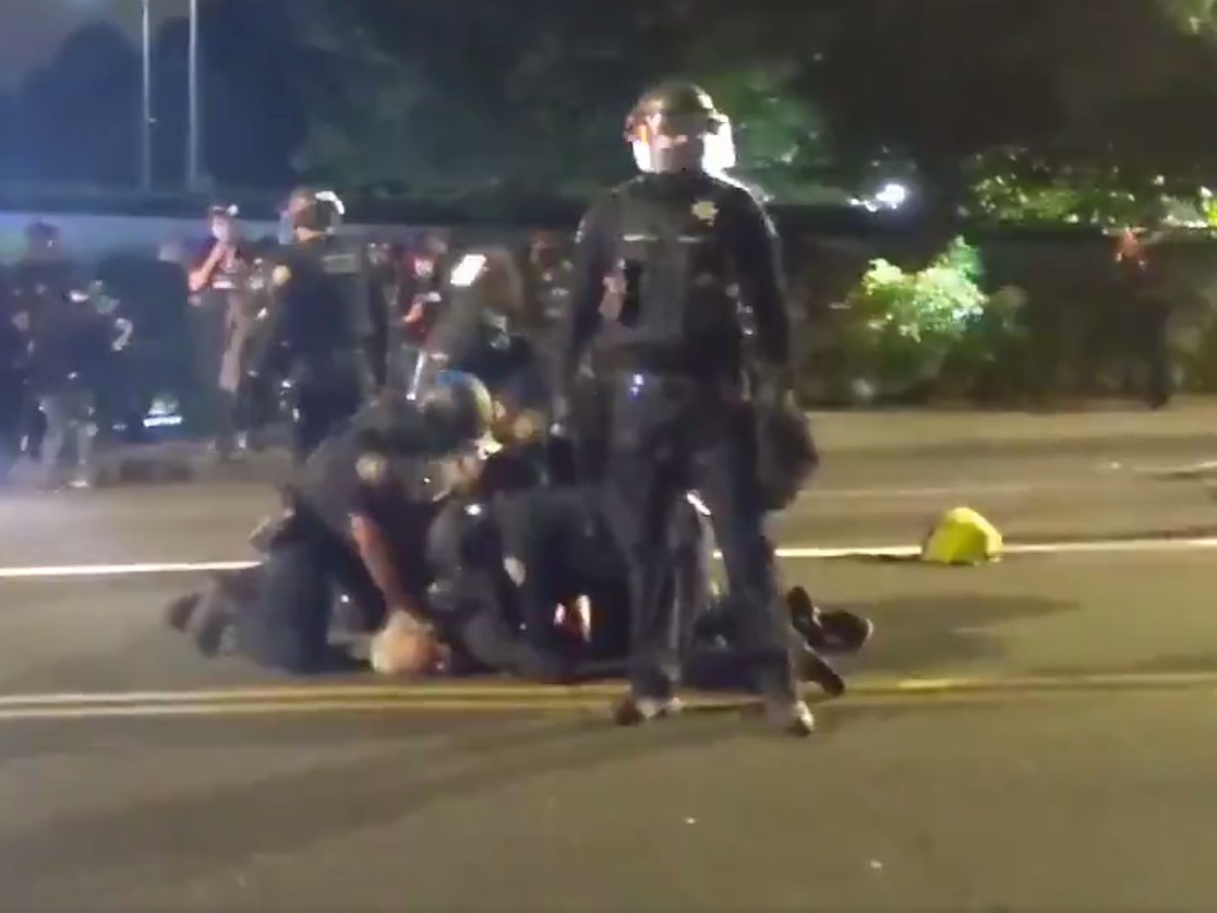 Police appear to repeatedly punch detained Portland protester who was lying in the road