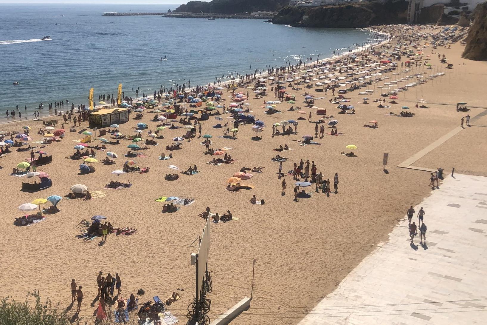 Waiting game: holidaymakers on the beach in the resort of Albufeira on the Algarve