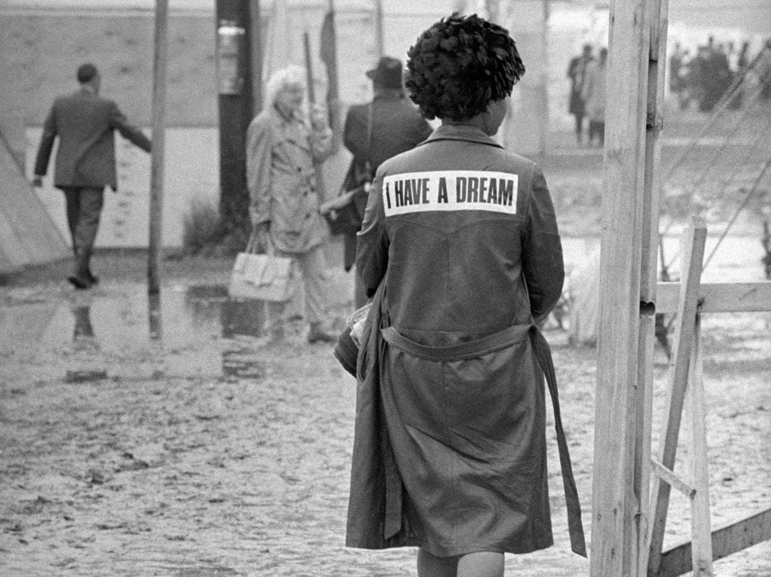 A woman wearing an ‘I have a dream’ slogan jacket walking through the shantytown known as ‘Resurrection City’ in Washington DC in 1968 (Rex)