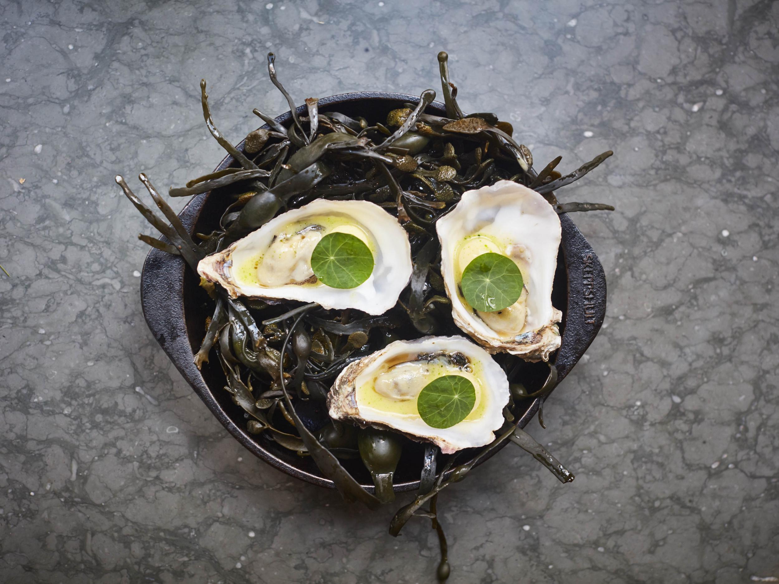 Flambadou oysters cooked with flaming beef fat and garnished with smoked apple and beurre blanc