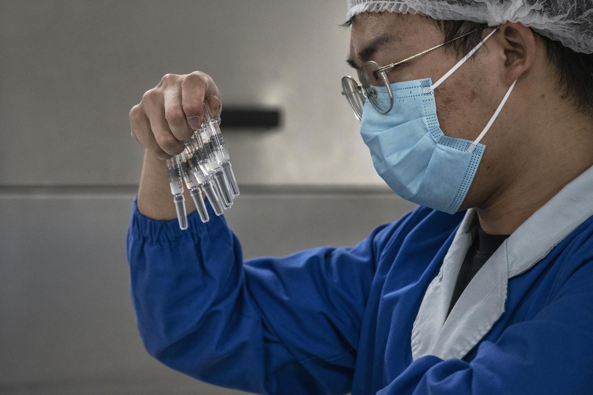 A worker checks syringes in Beijing