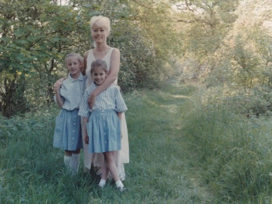 A young Caroline Flack pictured alongside her twin sister Jody and mother Christine