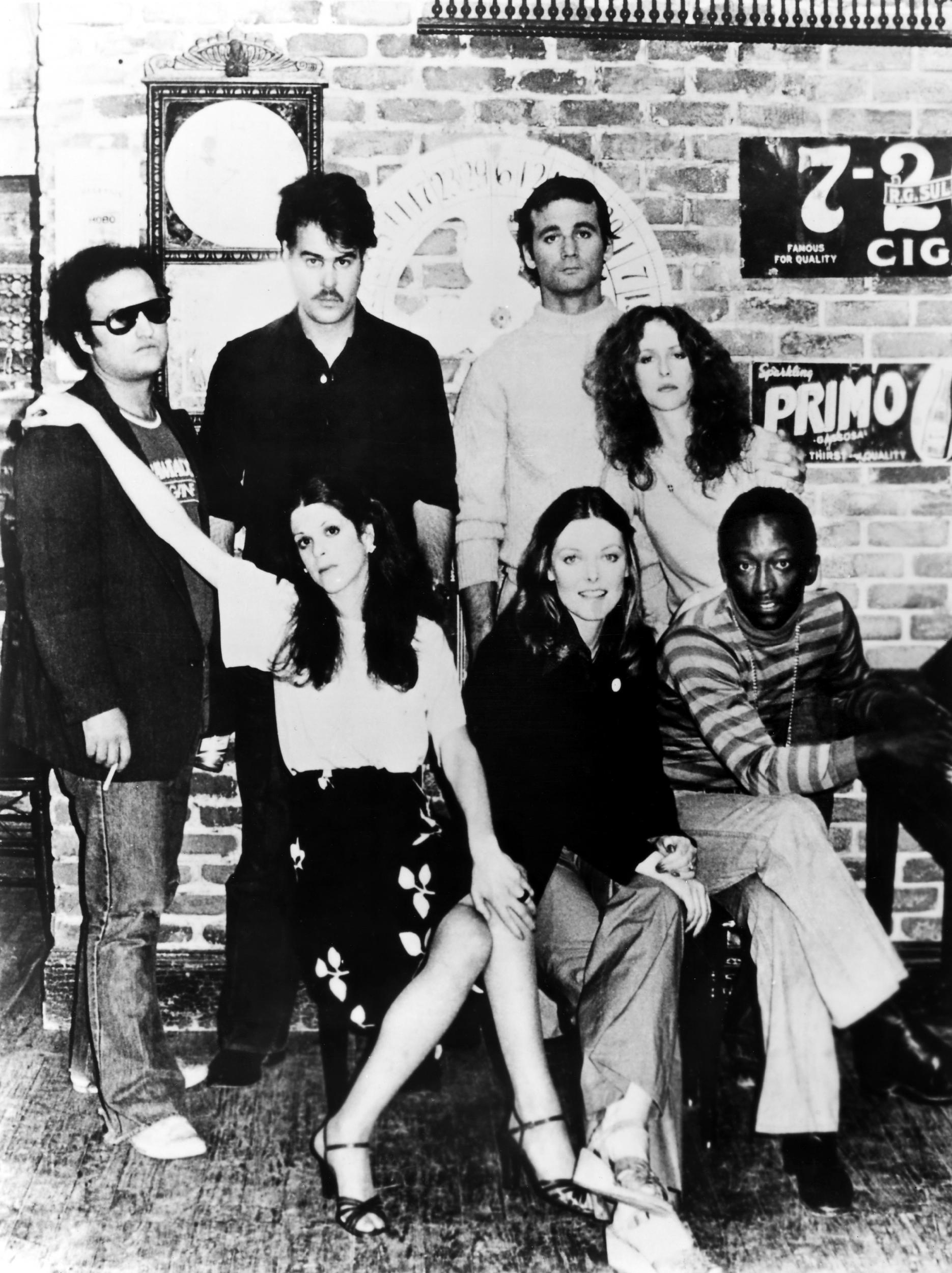 Saturday Night Live, 1977. Left To Right: (Standing) John Belushi, Dan Aykroyd, Bill Murray, Laraine Newman; (Seated) Gilda Radner, Jane Curtin, Garrett Morris.